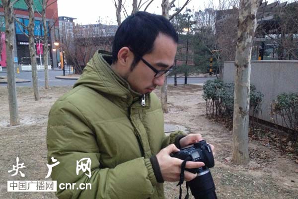 記者想為王崗拍張照片，而他熟稔地拿過相機開始調設置